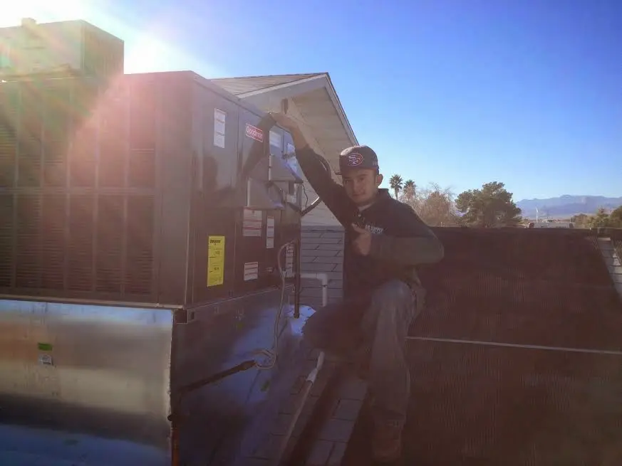 HVAC technician performing Heat Pump Repair on a rooftop unit in Stillwater